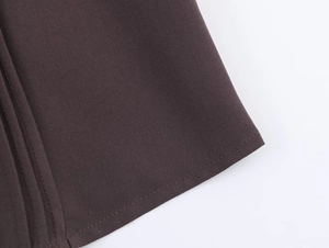 Detail view of chocolate brown woven fabric with fine stitching and textured weave