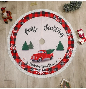 Detail of burlap Christmas tree skirt with red truck print and white tassel fringe