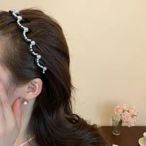 Elegant wavy pearl headband with inlaid rhinestones on a model in a warm setting
