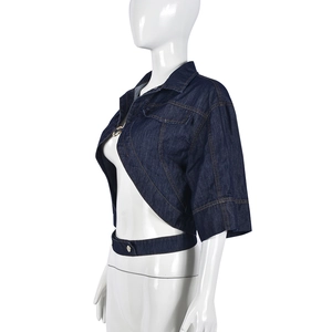 Detail of dark blue denim cropped jacket featuring gold stitching and metal buckle
