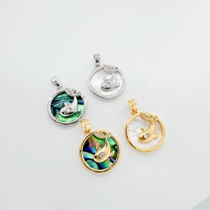 Macro view of whale-shaped pendants with 18K gold plating and inlaid natural shells