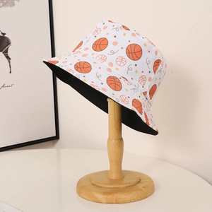 Detail of reversible bucket hat with orange basketball print on white canvas material