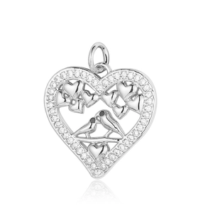 Macro detail of silver heart pendant with cubic zirconia inlay and bird engraving
