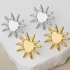 Detail of irregular sun heart earrings in gold and silver finish on stone base
