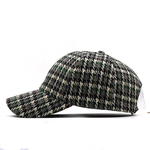 Detail of classic houndstooth baseball cap featuring green and brown woven fabric texture