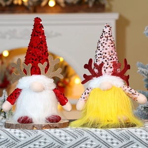 Detail of sequined Christmas gnome plush with reindeer antlers on rustic wood base
