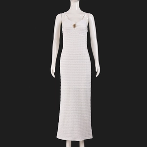 Détail du tissu en maille 3D blanche sur une robe moulante avec bouton doré