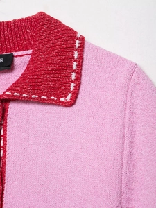 Detailed close-up of pink knit cardigan featuring decorative white contrast stitching