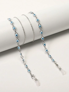 Detail of silver evil eye glasses chain with blue beads on white display stand