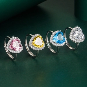 Vue détaillée de quatre bagues cœur ajustables avec zircons colorés au fini argenté