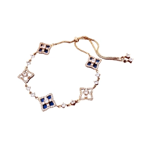 Gold-tone bolo bracelet featuring diamond-shaped blue gemstones and zircon hollow charms