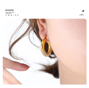 Close-up of elegant gold hoop earrings with sparkling pavé crystals on the model