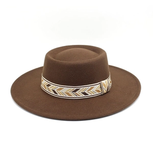 Detailed view of the dark brown flat-brimmed felt hat with patterned woven ethnic band