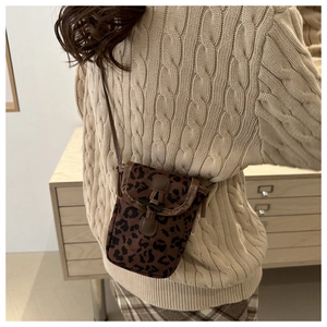 Detail of trendy leopard print mini crossbody phone bag on a cable-knit sweater