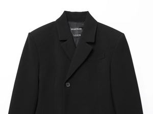 Vue détaillée du col et des boutons du blazer noir avec étiquette de taille sur blanc