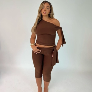 Detail of high-stretch dark brown one-shoulder top and high-waisted shorts set