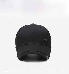 Detail of black cotton baseball cap showing side metal badge and grey ribbon accent