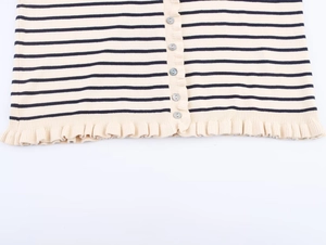 Détail d'un cardigan en tricot rayé avec boutons gris et ourlet à volants élégant