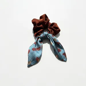 Detail of elegant two-tone scrunchie showing 13cm ribbon length and floral fabric texture