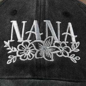 Adjustable black cotton baseball cap featuring high-quality white NANA flower embroidery