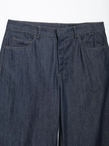 Dettaglio ravvicinato della vita di jeans blu scuro con cuciture a contrasto e taschino