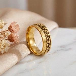 Gros plan de la bague chaîne dorée avec cristaux sur une surface marbrée