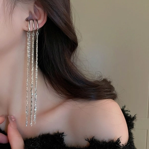 Detailed view of elegant silver triple-layered ear cuff with long metallic chain tassels