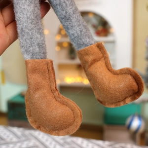Detailed close-up of handmade felt boots and knitted legs on a Christmas gnome doll