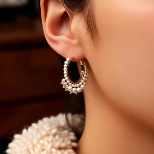 Detail of French vintage gold hoop earrings with cream pearls and sparkling crystals on model