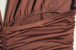 Detailed view of brown fabric featuring ruched design and high-quality stitching texture