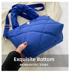 Detailed close-up showing the reinforced base and stitching of the blue quilted tote bag