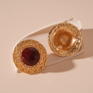 Detailed view of vintage gold stud earrings with wheat pattern and red resin center