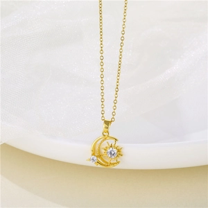Macro view of gold stainless steel sun and moon pendant necklace with zircon stones