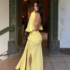 Detail of yellow backless dress featuring elegant ruched draping and a high side slit