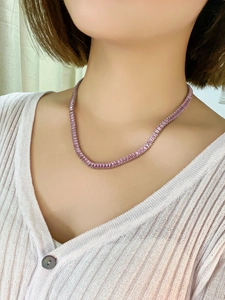 Close-up of pink sugar-loaf cut crystal necklace worn by model on a tennis chain