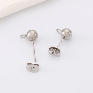 Macro view of silver stainless steel ball stud earrings with hanging loops and butterfly backs