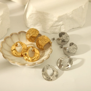 Boucles d'oreilles créoles dorées et argentées texturées sur pierre blanche