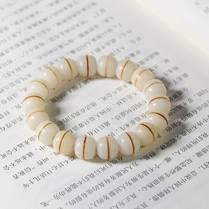 Macro shot of cream Bodhi root beads with charcoal-fired cat paw texture on a book