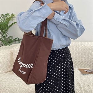 Detail of large brown tote bag with Bonjour magic print and fuzzy fleece lining