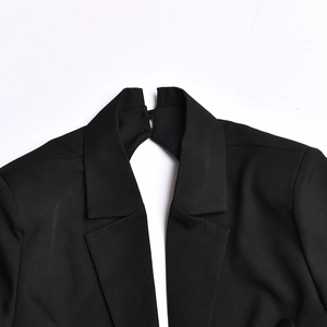 Detail view of the black dress featuring a back neck cutout and button closure design