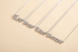 Detailed macro of silver stainless steel necklaces with Gothic zodiac pendant fonts