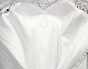 Detail of white bridal gown interior with lace trim and structural boning support