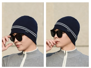 Detail view of navy blue ribbed knit beanie with grey stripes and FBQE logo label