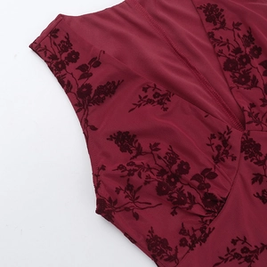 Detailed view of the V-neckline featuring burnout floral pattern on deep red fabric