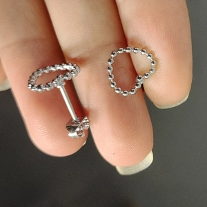 Detailansicht der silbernen Herzohrringe mit Metallperlen-Design und Schmetterlingsverschluss