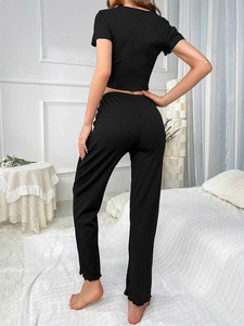 Rear view of black ribbed pajama set featuring short crop top and wavy edge pants