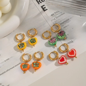 Gros plan détaillé de boucles d'oreilles cœur colorées avec motifs floraux en émail