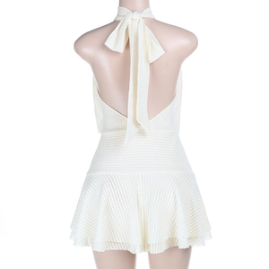 Detail of cream halter mini dress showing open back with tie-up bow and textured mesh