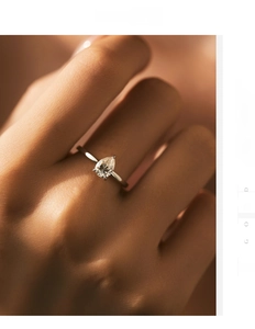 Close-up of a pear-cut moissanite ring in S925 sterling silver on a woman's finger