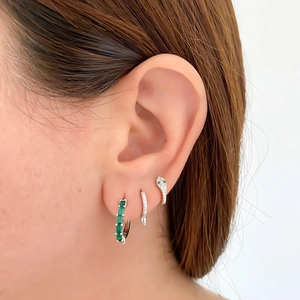 Detail of S925 silver snake earring with emerald stone and spiked zircon stud earrings